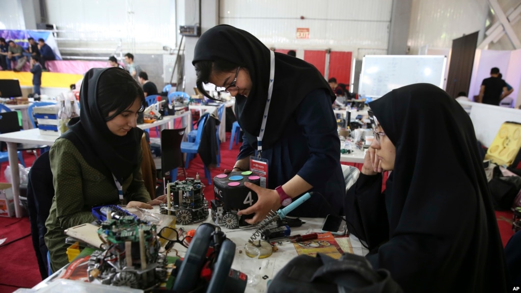 FILE - In this April 6, 2016, file photo, Iranian students prepare their robots during the international robotics competition, RoboCup Iran Open 2016, in Tehran, Iran. Universities in the U.S. say President Donald Trump's revised travel ban would block hundreds of graduate students who play key roles in research. Twenty-five of America's largest universities told The Associated Press they've sent acceptance letters to more than 500 students from the six banned countries for next fall, mostly from Iran, who are known for their strength in engineering and sciences.
