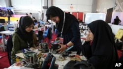 FILE - In this April 6, 2016, file photo, Iranian students prepare their robots during the international robotics competition, RoboCup Iran Open 2016, in Tehran, Iran. Universities in the U.S. say President Donald Trump's revised travel ban would block hundreds of graduate students who play key roles in research. Twenty-five of America's largest universities told The Associated Press they've sent acceptance letters to more than 500 students from the six banned countries for next fall, mostly from Iran, who are known for their strength in engineering and sciences.