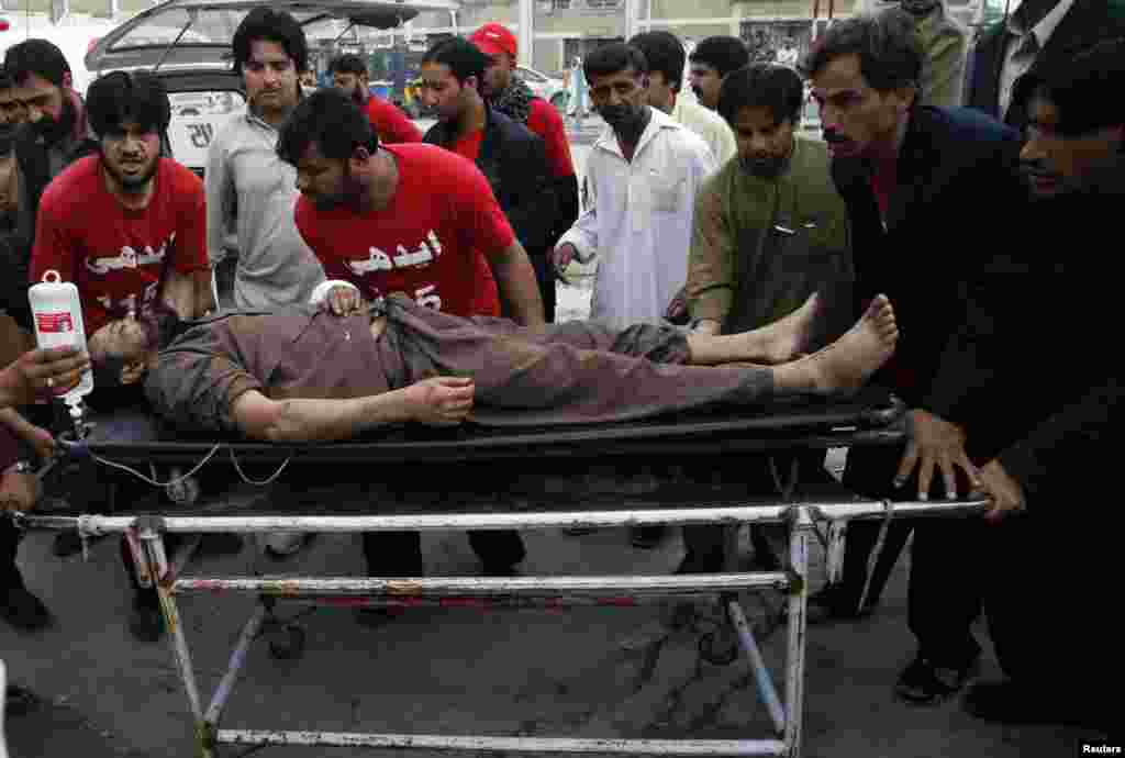 Rescue workers move a wounded man after a bomb attack in Quetta, Pakistan, April 24, 2013. 