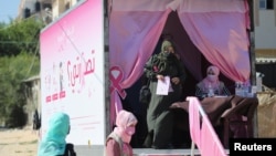 Seorang perempuan Palestina meninggalkan klinik keliling yang didirikan di sebuah truk setelah pemeriksaan payudara untuk deteksi dini kanker, di Khan Yunis, Jalur Gaza, 7 Oktober 2021. (REUTERS/Ibraheem Abu Mustafa)