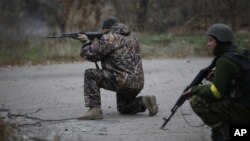 FILE - Ukrainian volunteer fighters are seen holding their weapons in the village of Peski, near Donetsk, eastern Ukraine, Nov. 12, 2014.