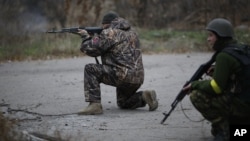 지난 12일 우크라이나 동부 도네츠크 인근 페스키 마을에서 우크라이나 자원 병력이 총을 겨누고 있다.