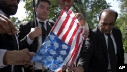 Pakistani lawyers burn a representation of the U.S, flag during a demonstration at an area that houses the U.S. Embassy and other foreign missions in Islamabad, Pakistan, September 19, 2012. 