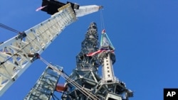 The silver spire topping One World Trade Center in New York is lifted as it is fully installed on the building's roof, bringing the structure to its full, symbolic height of 1,776 feet on May 10, 2013 .