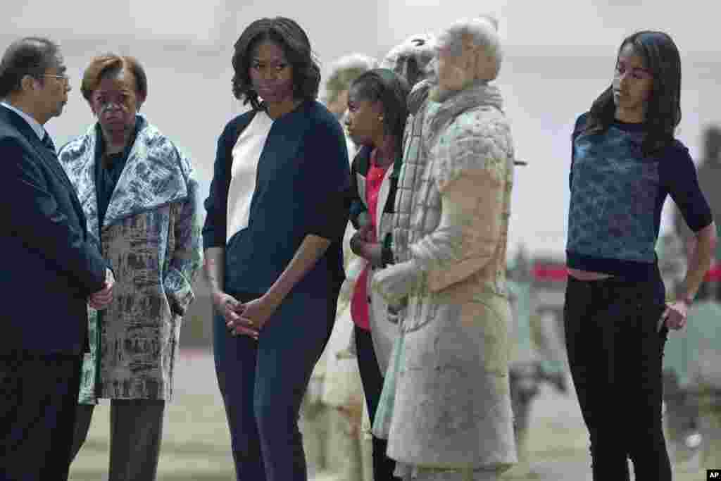 U.S. first lady Michelle Obama looks at a terracotta warrior as she visits Qinshihuang Terracotta Warriors and Horses Museum with her daughters, Malia and Sasha, and her mother, Marian Shields Robinson, in Xi'an, March 24, 2014. 