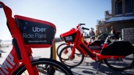 Uber's Jump electric bike share bicycles are seen along Mission Beach boardwalk Tuesday, May 28, 2019, in San Diego. (AP Photo/Gregory Bull)