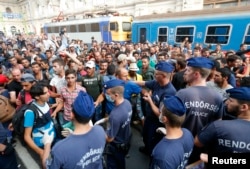 Migrants face Hungarian police in the main Eastern Railway station in Budapest, Hungary, Sept. 1, 2015.