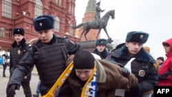 Police officers detain a protester in central Manezhnaya Square in Moscow, on March 2, 2014, during an unsanctioned rally against the Russia's military actions in Crimea.