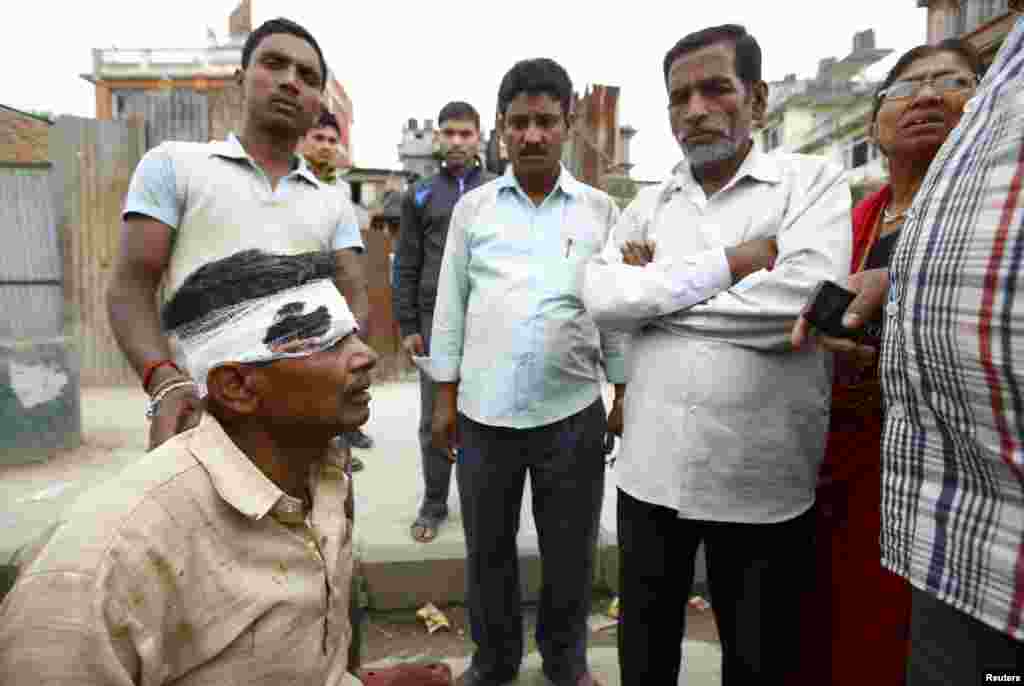 A victim injured in an earthquake sits along a road in Kathmandu, Nepal, April 25, 2015.