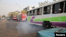 FILE - A bus leaves as smoke is seen at a bus park in Abuja, Nigeria, February 1, 2017. The bus involved in the fatal March 23, 2023 crash was in Bauchi State in the north of the country.