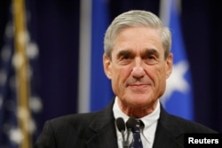FILE - Robert Mueller pauses during his remarks at a farewell ceremony held for him at the Justice Department in Washington.