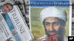 A roadside vendor sells newspapers with headlines about the death of al-Qaida leader Osama bin Laden in Lahore, Pakistan, May 3, 2011.