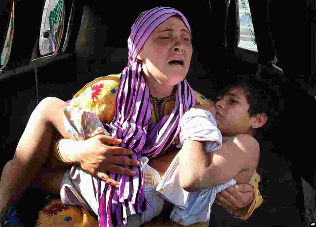 May 30: A Syrian woman cries as she carries her son who was shot in the hand by a Syrian border guard when they were crossing a river from Syria to Lebanon, at the northern border town of Wadi Khaled, north Lebanon.