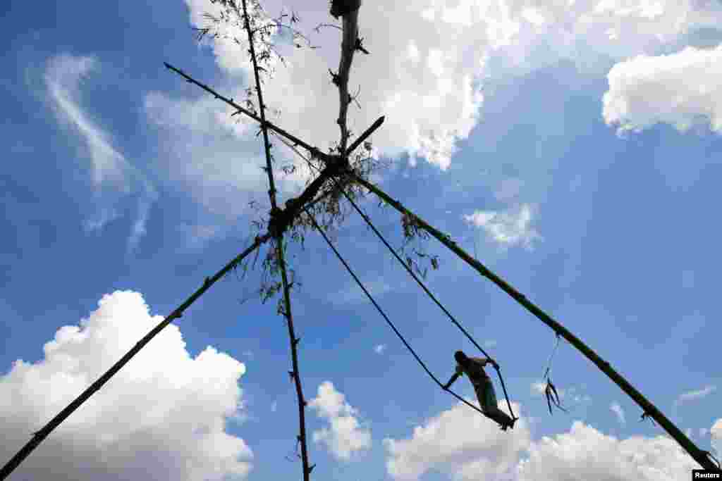 A boy plays on a traditional swing during Dashain, the biggest religious festival for Hindus in Nepal, in Kathmandu, Nepal.