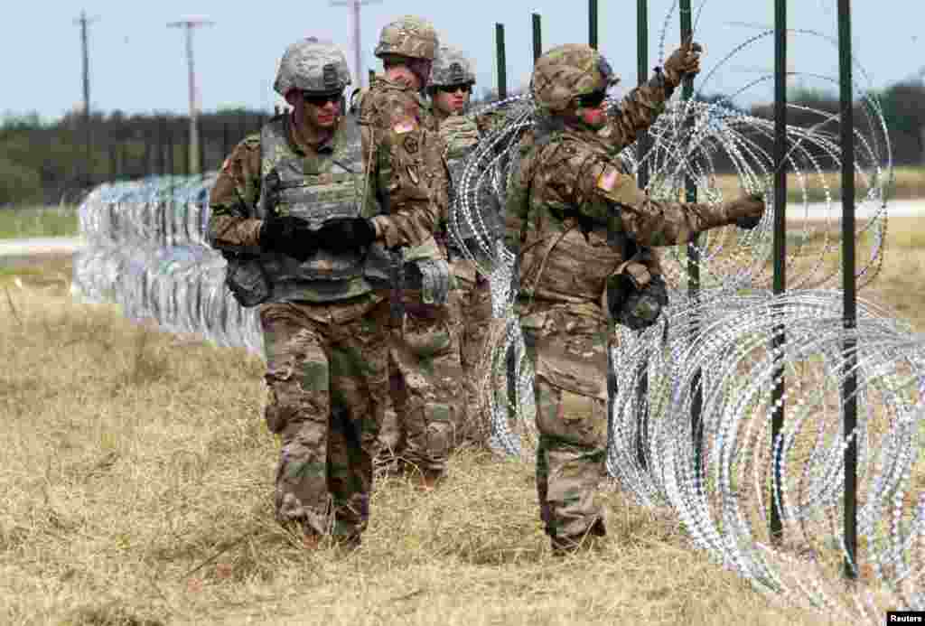 U.S. Army soldiers from Ft. Riley, Kansas, put up barbed wire fence for an encampment to be used by the military near the U.S. Mexico border in Donna, Texas, Nov. 4, 2018.