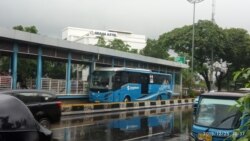 Bus Transjakarta yang beroperasi di sekitar Gereja Katedral Jakarta pada Hari Natal, Rabu, 25 Desember 2019. (Foto: Sasmito Madrim/VOA)