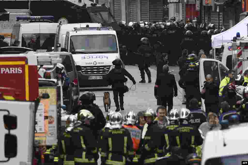 프랑스 경찰이 파리 북부 외곽 생드니의 테러 용의자 은신처를 급습한 가운데, 무장 경찰과 폭발물탐지견, 소방관들이 현장 주변에 출동해있다.