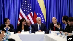Vice President Mike Pence, second from right, listens with Sen. Marco Rubio, R-Florida., left, Venezuelan exile Maria Eugenia Tovar, and Florida Gov. Rick Scott, right, as a former political prisoner from Venezuela speaks at Our Lady of Guadalupe Catholic Church, Aug. 23, 2017, in Doral, Florida.