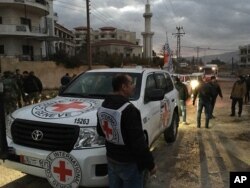 FILE - A convoy containing food, medical items, blankets and other materials arrives in the town of Madaya, Syria, Jan. 11, 2016.