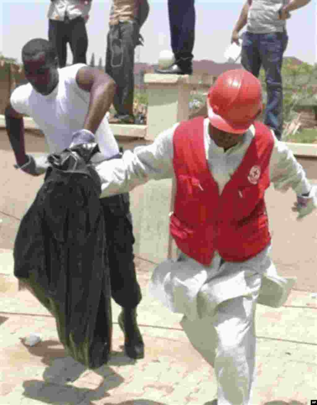 Rescuers remove body parts at the bombed office of ThisDay, an influential daily newspaper in Abuja, Nigeria, Thursday, April. 26, 2012.