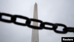 El obelisco de Washington visto detrás de una cadena de seguridad, en la Alameda Nacional simboliza el cierre parcial del gobierno federal, que el martes 15 de enero cerró su vigésimo quinto día, sin visos de solución.