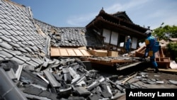 15일 일본 도쿄 남부 구마모토현에 강진이 발생한 가운데, 구조대가 무너진 가옥을 수색하고 있다.
