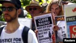 FILE - Protesters react as they hold placards and listen to speakers during a rally in support of refugees in central Sydney, Australia, Oct. 19, 2015. Papua New Guinea's Supreme Court ruled Tuesday that Australia's detention of asylum seekers at a facility on the Pacific nation's Manus Island is unconstitutional.
