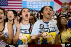 Members of the audience cheer as Democratic presidential candidate Hillary Clinton speaks at a rally at Palm Beach State College in Lake Worth, Florida, Oct. 26, 2016.