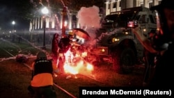 USA, Visconsin, Kenosha, An incendiary device goes off in front of a Kenosha Country Sheriff Vehicle as demonstrators take part in a protest following the police shooting of Jacob Blake