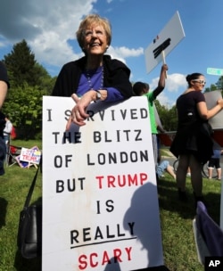 FILE - A voter holds a sign as she stands with others outside an event where Republican presidential candidate, Donald Trump and New Jersey Gov. Chris Christie were to appear on May 19, 2016 in Lawrenceville, N.J.