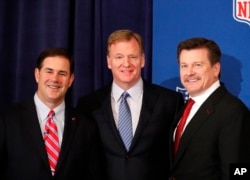 El gobernador de Arizona, Doug Ducey, posa con el comisionado de la NFL, Roger Goodell, y el propietario de los Cardinals de Arizona, Michael Bidwill, después de una conferencia de prensa durante la reunión de primavera de los propietarios de la NFL, donde Goodell anunció que Phoenix será el anfitrión del Super Bowl en 2023. Mayo 23 de 2018.