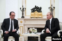 FILE - Russia's President Vladimir Putin, right, meets with French President Francois Hollande at the Kremlin in Moscow, Russia, Nov. 26, 2015. The leaders discussed coordinating efforts to combat Islamic State militants.