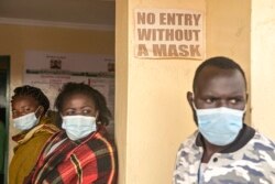 FILE - People wait to be vaccinated against COVID-19 at Ngando informal settlement in Nairobi, Kenya, Dec. 16, 2021.