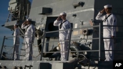 Navy sailors aboard the USS Halsey salute the USS Utah Memorial in Honolulu, Dec. 7, 2016. 