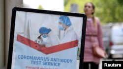 A advertising sign for a coronavirus disease (COVID-19) antibody test service is seen outside a pharmacy, in London, Britain, June 29, 2020. REUTERS/Toby Melville