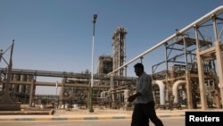FILE - A man walks past the Mahshahr petrochemical plant in Khuzestan province, southwest of Tehran, Iran, Sept. 28, 2011.