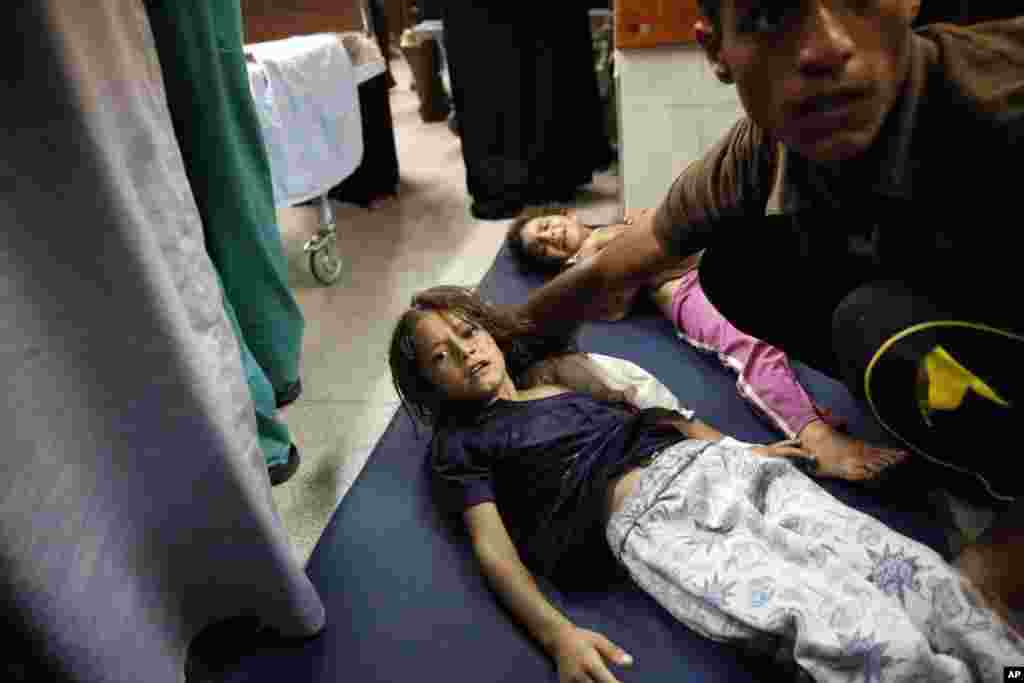 Palestinian children wounded after the shelling of a compound housing a U.N. school in Beit Hanoun in the Gaza Strip lay on the floor of an emergency room in Beit Lahiya, July 24, 2014.