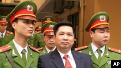 Cu Huy Ha Vu is escorted by policemen after his trial at a court in Hanoi, April 4, 2011. Vu, a legal scholar who sued Vietnam's prime minister and called for an end to one-party rule, was sentenced on Monday to seven years in prison.
