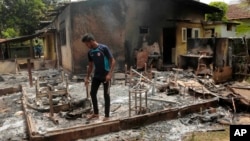 Seorang pria Muslim Sri Lanka memeriksa sisa-sisa tas menjahit yang hangus terbakar, pasca serangan kelompok garis keras Buddha Bodu Bala Sena di Aluthgama, 50 kilometer selatan Kolombo, Sri Lanka, Senin (16/6).