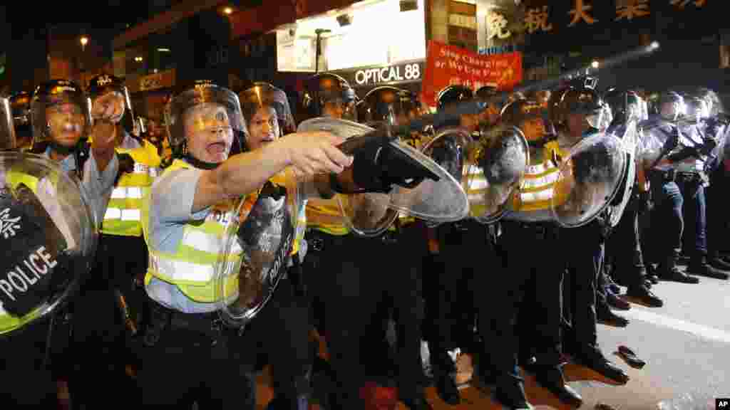Riot police officers advance on a pro-democracy protest encampment in the Mong Kok district of Hong Kong, Oct. 19, 2014. 