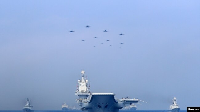 2018年4月12日在南中国海参加阅兵的中国军舰与战机。