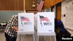 Voters fill in their ballots as they vote in the U.S. midterm elections at a polling place in Westminster, Colorado, Nov. 4, 2014.