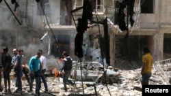 People inspect the damage at a site hit by airstrikes, in the rebel-held area of Aleppo's Bustan al-Qasr, Syria, April 28, 2016. 