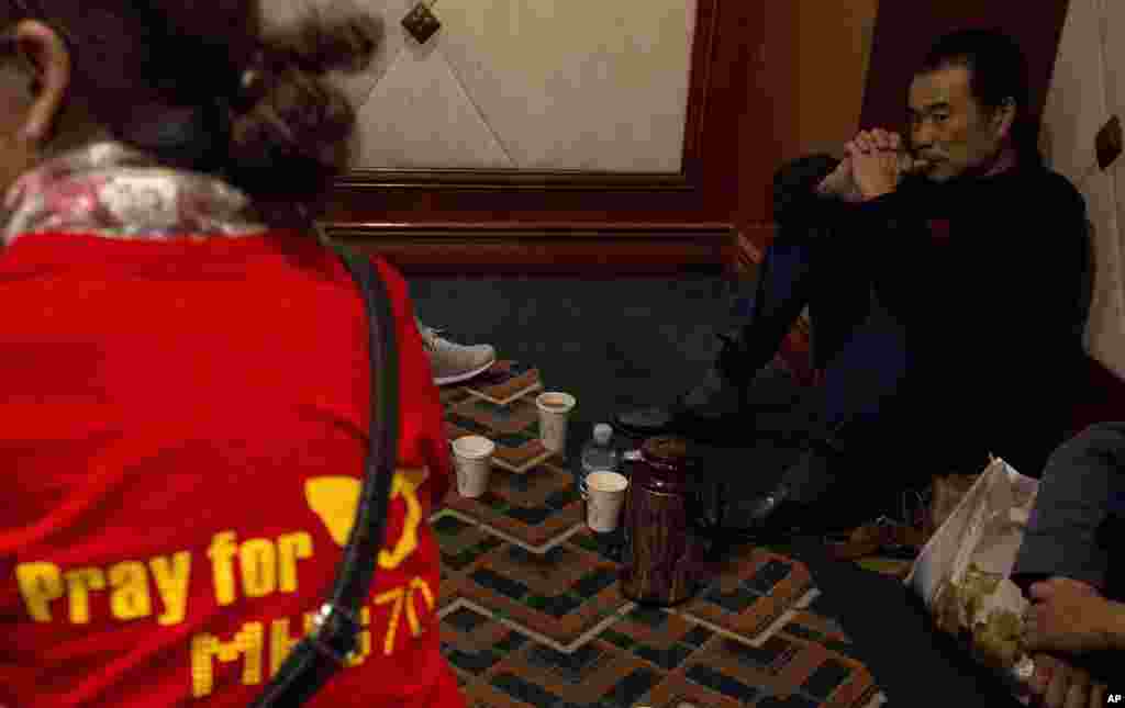 Relatives of passengers on Flight MH370 wait for news outside a conference room at a hotel in Beijing, April 8, 2014. 