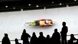 The German doubles team of Tobias Wendl and Tobias Arlt speed down the track during the luge team relay competition at the 2014 Winter Olympics, Feb. 13, 2014, in Krasnaya Polyana, Russia. 