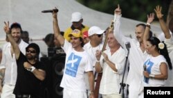 Los cantantes (de izquierda a derecha) Carlos Varela de Cuba, Juanes de Colombia, Víctor Manuel de España, Miguel Bosé de España y Olga Tañón de Puerto Rico saludan a la multitud al final del concierto "Paz sin fronteras" en La Habana, Cuba, el 20 de septiembre de 2009.