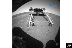 In this image released by the China National Space Administration (CNSA) on Saturday, May 22, 2021, a landing platform and the surface of Mars are seen from a camera on the Chinese Mars rover Zhurong. CNSA via AP)