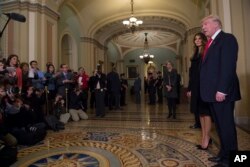 President-elect Donald Trump, accompanied by his wife, Melania, speaks to reporters and photographers on Capitol Hill in Washington after meeting with Senate Majority Leader Mitch McConnell of Kentucky, Nov. 10, 2016.