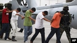 Alleged members of the Zetas cartel are escorted by members of the military as they are presented to the press after their arrests in Mexico City, Oct. 7, 2011.