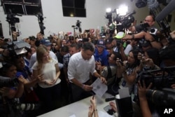 Presidential candidate Carlos Calleja, center, and his wife Andrea vote in presidential elections in San Salvador, El Salvador, Feb. 3, 2019.